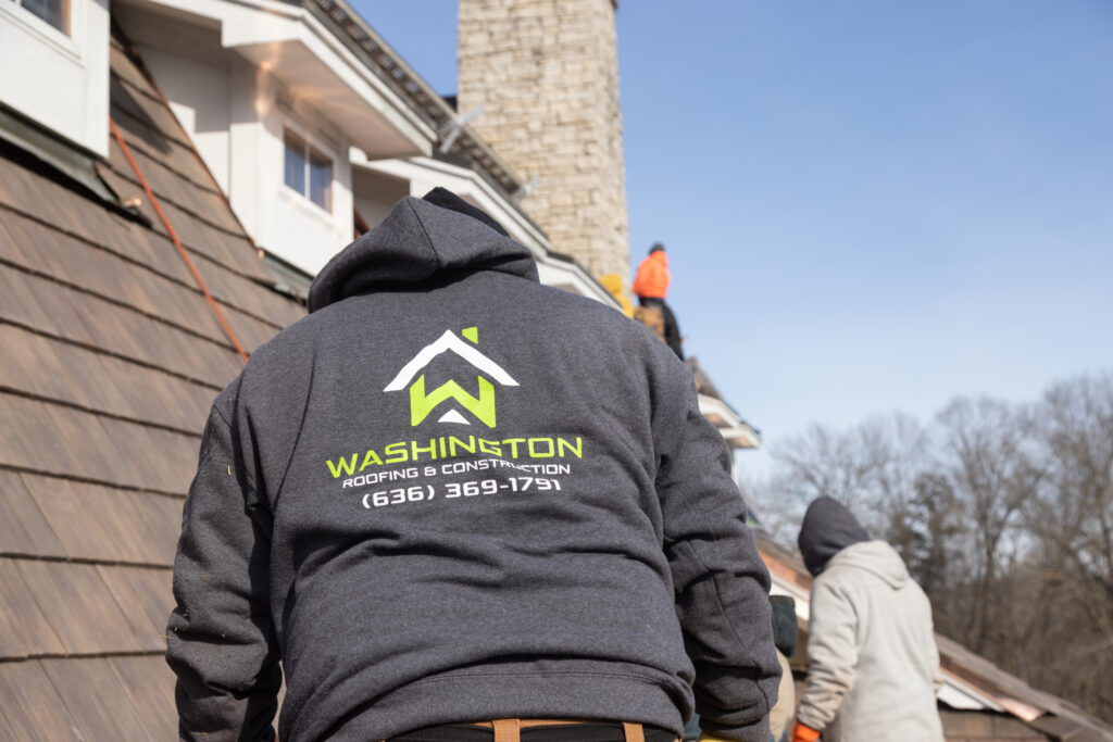 Washington Roofing & Construction crew installing a premium roofing system on a luxury home. Team members wearing company-branded apparel perform a professional roof replacement with expert craftsmanship, showcasing trusted residential roofing services, quality installation, and attention to detail.