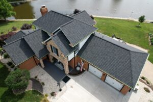 Drone view of a luxury home featuring a premium DaVinci grand manor shingle system professionally installed by Washington Roofing & Construction. This custom roofing installation showcases exceptional craftsmanship, durable synthetic slate roofing, copper accents, and enhanced curb appeal on a beautiful waterfront property, highlighting expert residential roof replacement services.