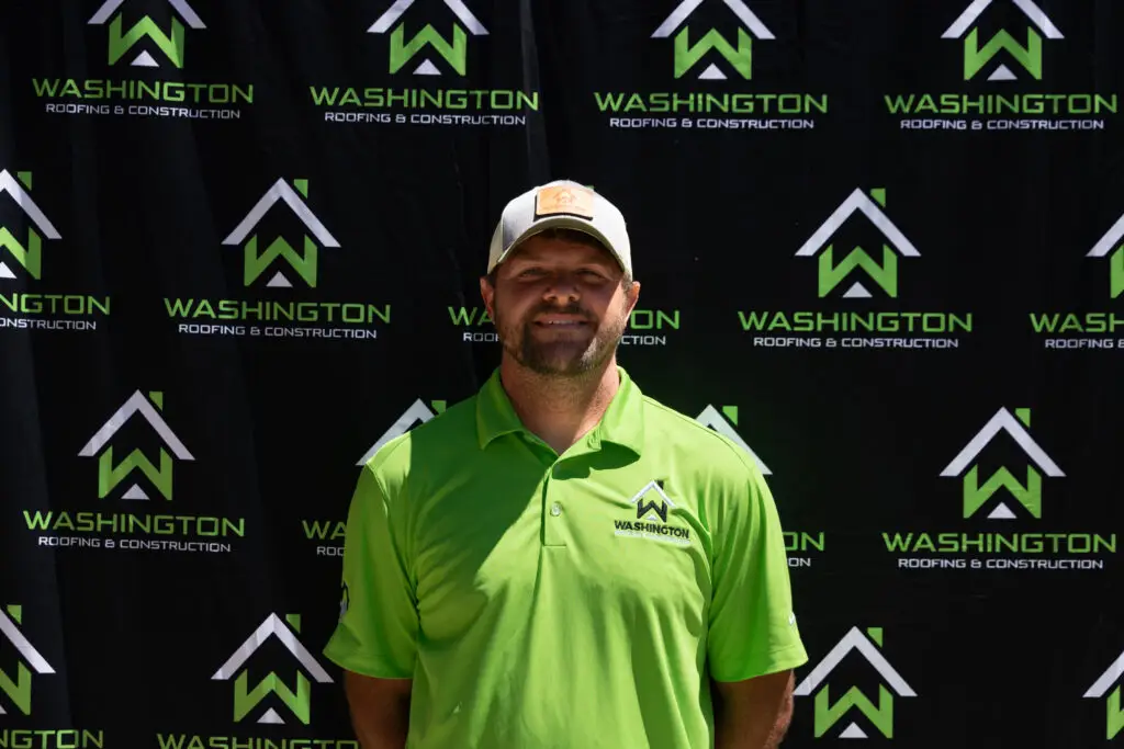 - Washington Roofing & Construction team member Derek Slocum - Sales team. standing in front of a backdrop featuring the logo and name "Washington Roofing & Construction.